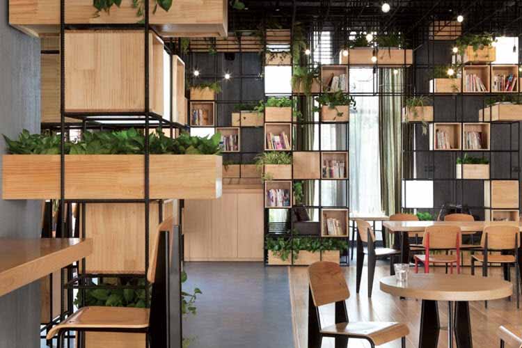 Vigas de acero y plantas dan forma a una cafeteria